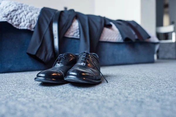 Formal attire on bed and leather shoes — Stock Photo, Image