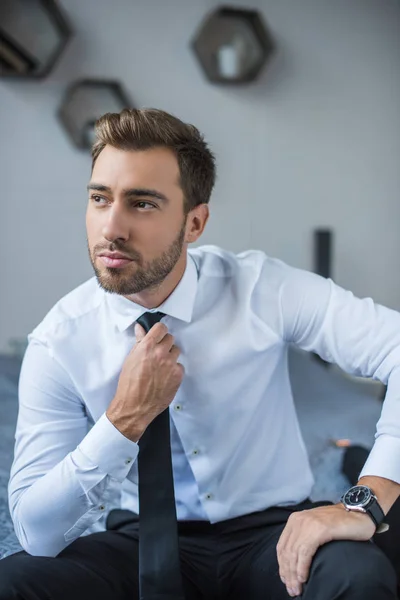 Бизнесмен выпрямляет галстук — стоковое фото