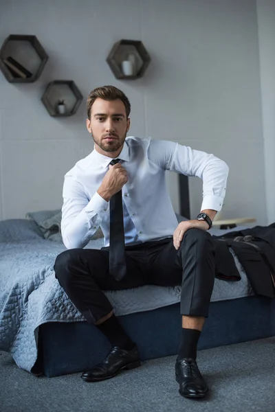 Biznesmen prostujący krawat — Zdjęcie stockowe