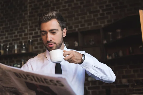 Zakenman drinken koffie en het lezen van de krant — Stockfoto