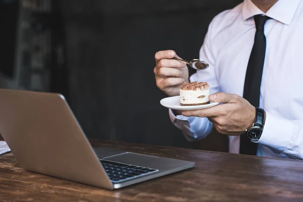 Homem de negócios com laptop e bolo — Fotografia de Stock