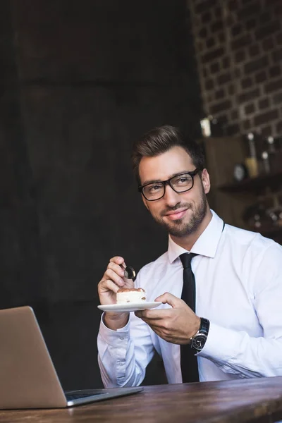 Бізнесмен їсть торт в кафе — Безкоштовне стокове фото