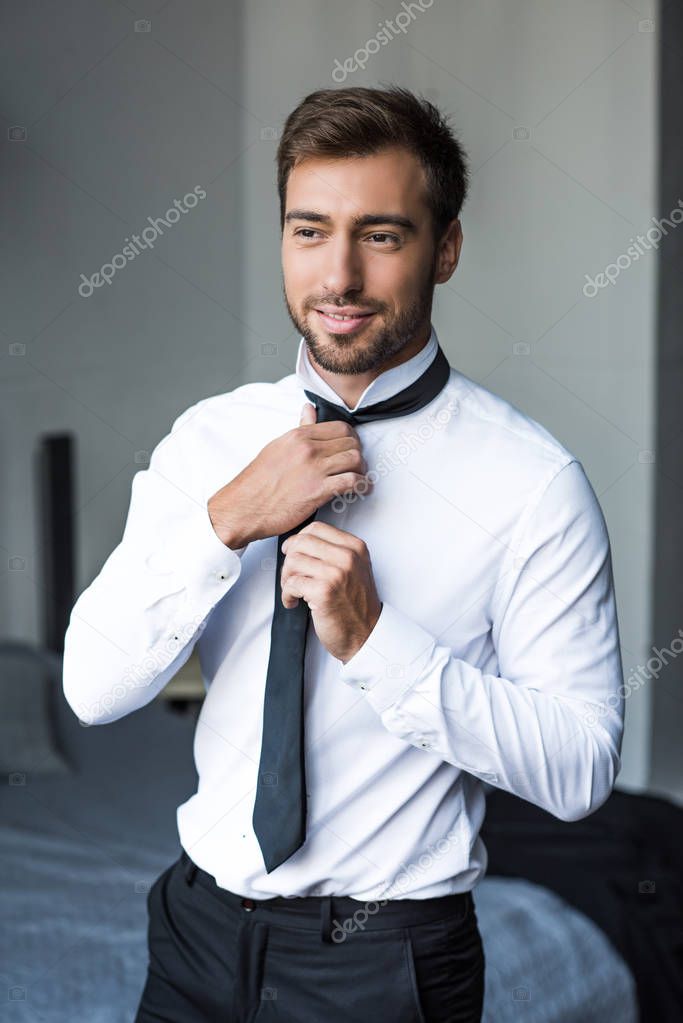 businessman putting on tie