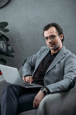 Dizüstü bilgisayar kullanan iş adamı