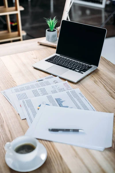 Cup of coffee and laptop on table — Stock Photo, Image