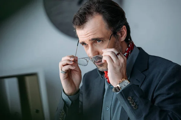 Businessman holding eyeglasses — Stock Photo, Image