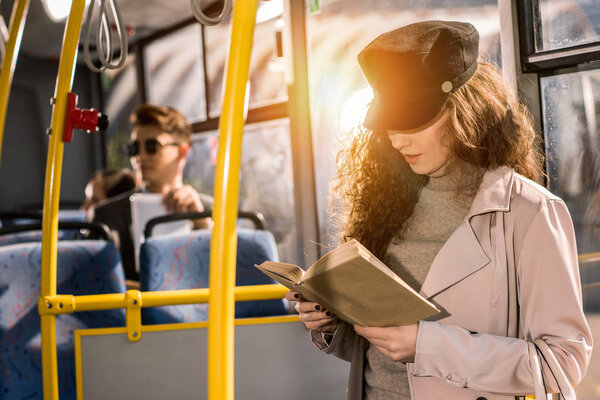 girl reading book in bus 