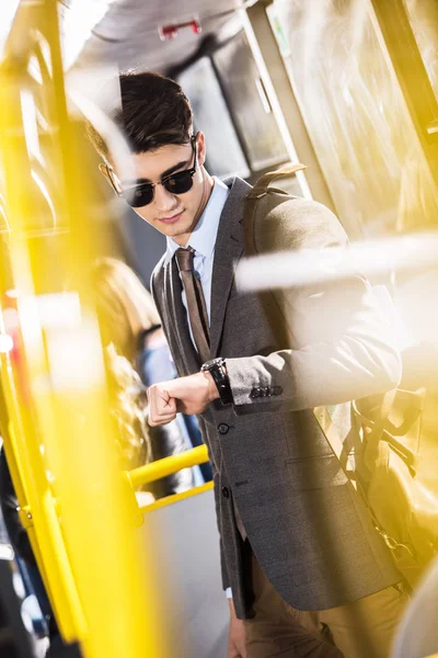 Businessman checking wristwatch in bus — Stock Photo, Image