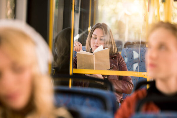 girl reading book in bus 