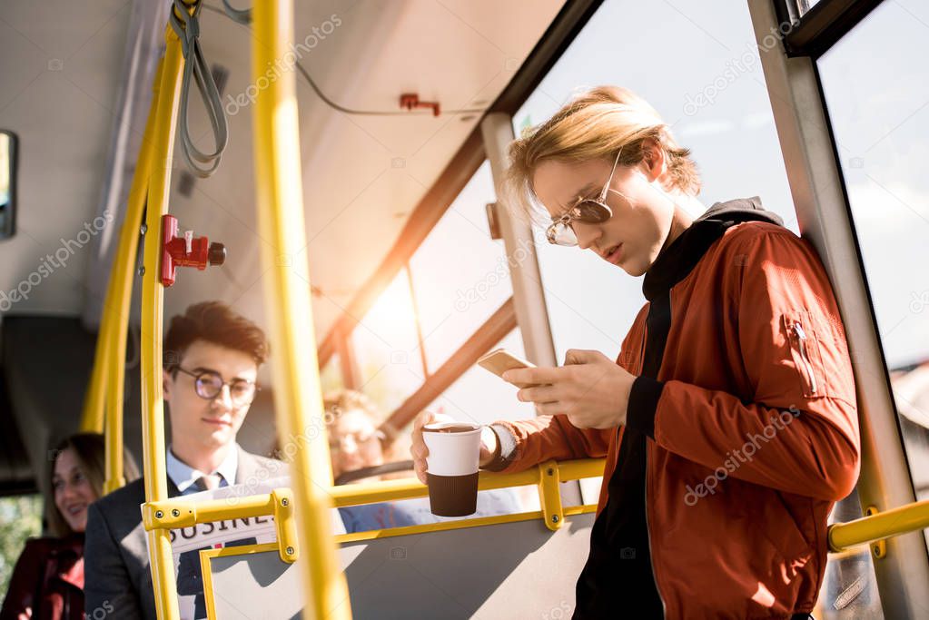 man using smartphone in bus