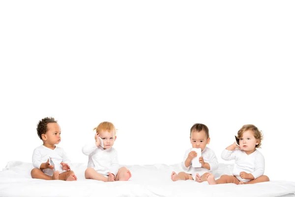 Niños pequeños multiculturales sosteniendo teléfonos inteligentes — Foto de Stock