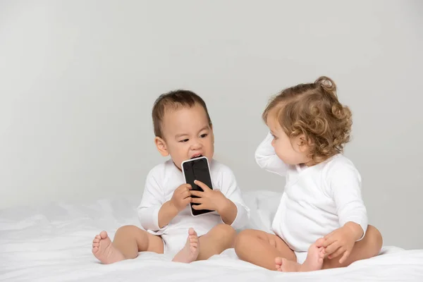 Мультикультурные малыши с цифровым смартфоном — стоковое фото
