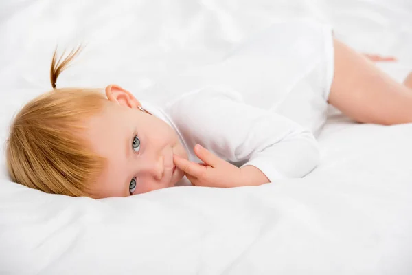 Ребенок, лежащий на кровати — стоковое фото