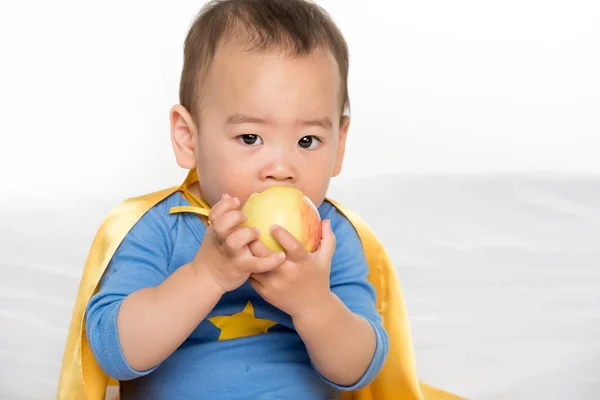 Азиатский ребенок ест яблоко — стоковое фото