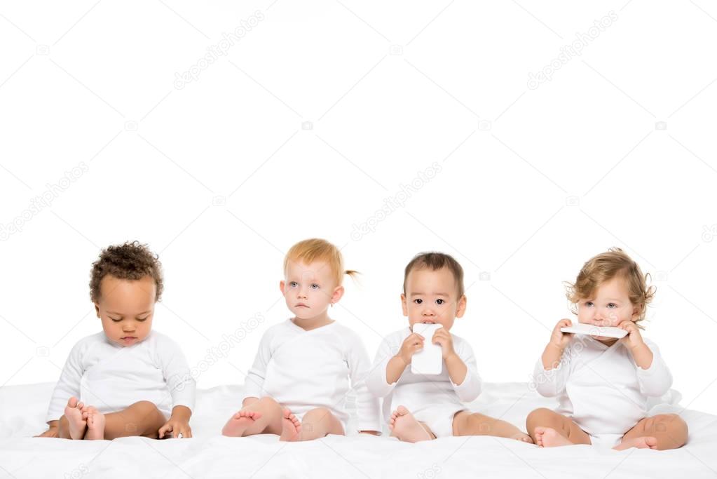 multicultural toddlers holding smartphones