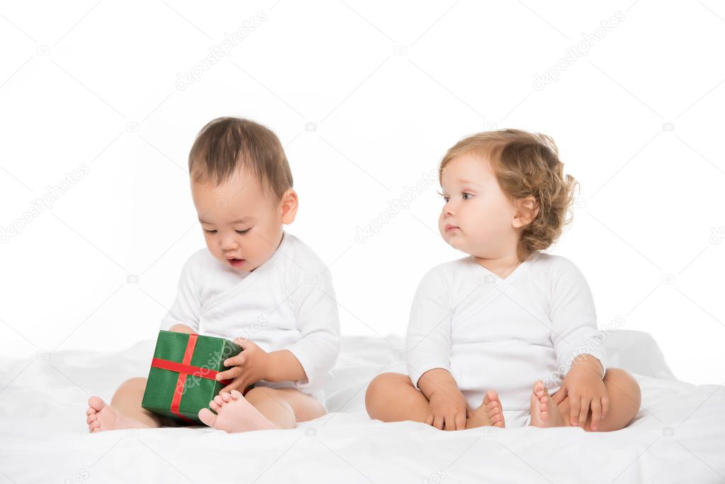 multiethnic toddlers with wrapped gift