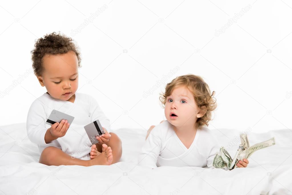 multiethnic toddlers with money