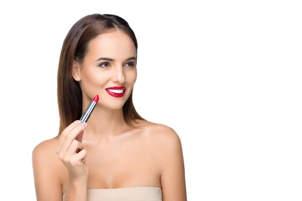 Young woman applying lipstick — Free Stock Photo