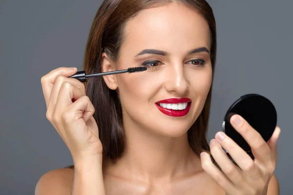 Mujer joven aplicando maquillaje —  Fotos de Stock