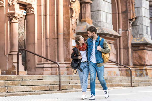 модная пара, идущая по улице
