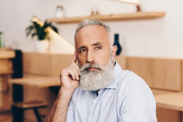 Senior man talking on smartphone in cafe — Free Stock Photo