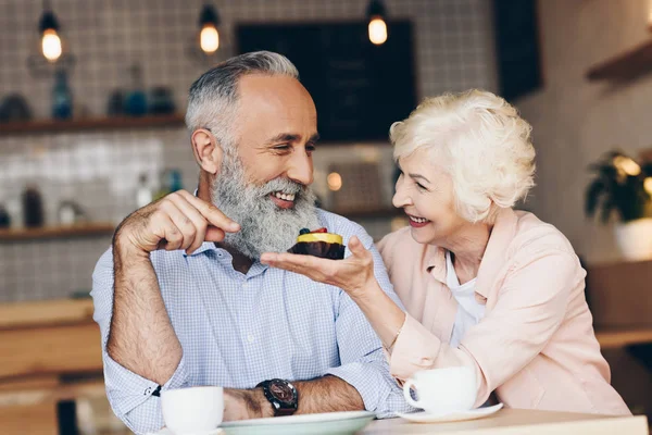 Elderly couple at table in cafe — Stock Photo, Image