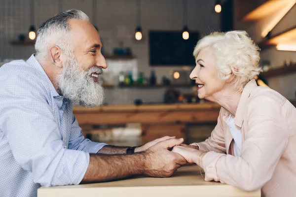 Pareja de ancianos tomados de la mano en la cafetería —  Fotos de Stock