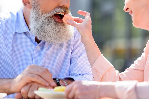 Woman feeding husband with macaroon — Stock Photo, Image