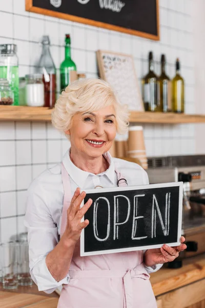 Senior worker with open chalkboard — Free Stock Photo