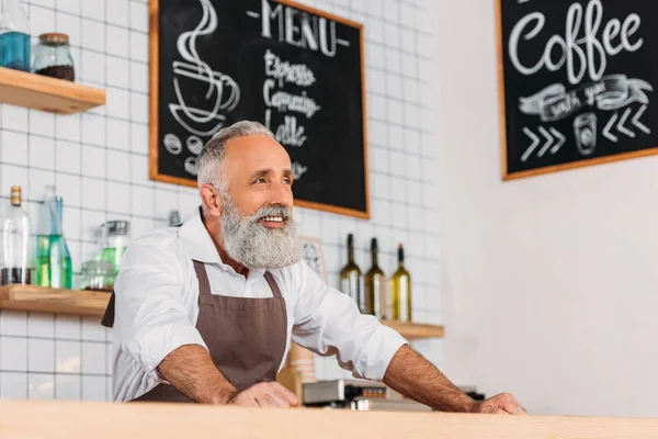 Senior worker standing at counter — Stock Photo, Image
