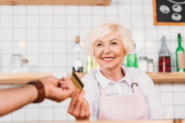 Visitante dando tarjeta de crédito al trabajador de la cafetería — Foto de Stock