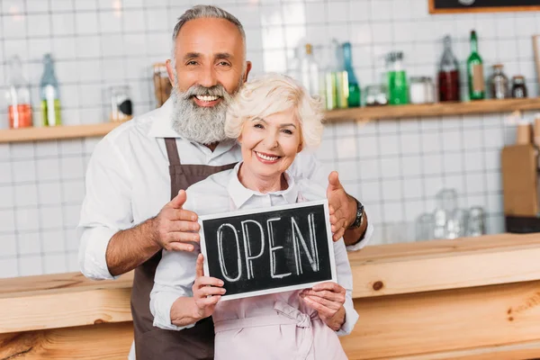 Coffee shop owners with open chalkboard — Stock Photo, Image
