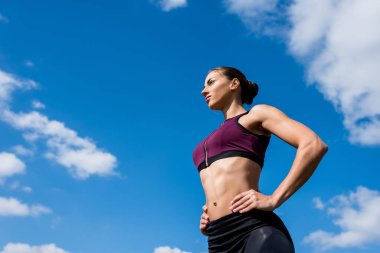 Sportif kadının önünde mavi gökyüzü