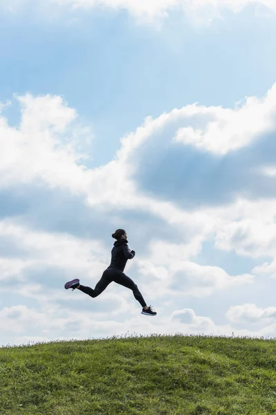 Sportieve vrouw springen op heuvel — Stockfoto