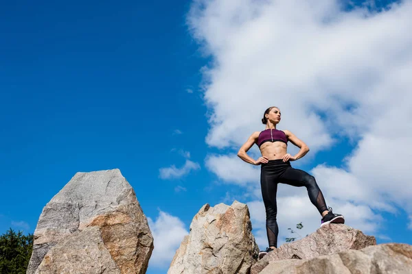 Donna atletica in piedi sulle rocce — Foto Stock