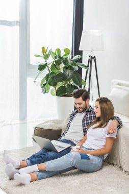 Genç çift dizüstü bilgisayar kullanıyor