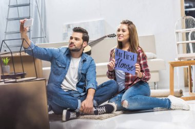 couple sitting on floor and taking selfie clipart