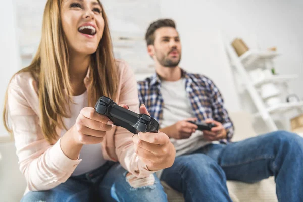 Пара, играющая в видеоигры с геймпадами — стоковое фото