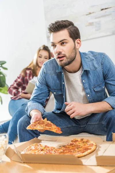Чоловік тримає скибочку піци — стокове фото
