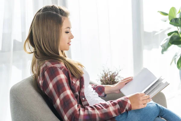 Kvinna på soffa läsa bok — Stockfoto