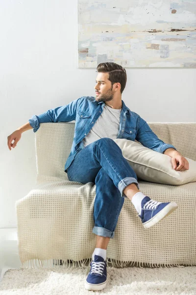 Attractive man sitting on sofa — Stock Photo, Image