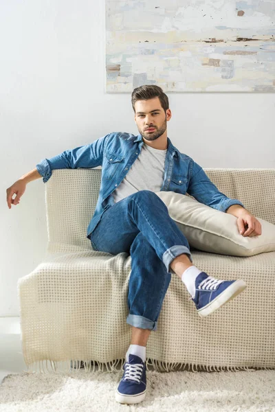 Ελκυστικός άνδρας κάθεται στον καναπέ — Φωτογραφία Αρχείου