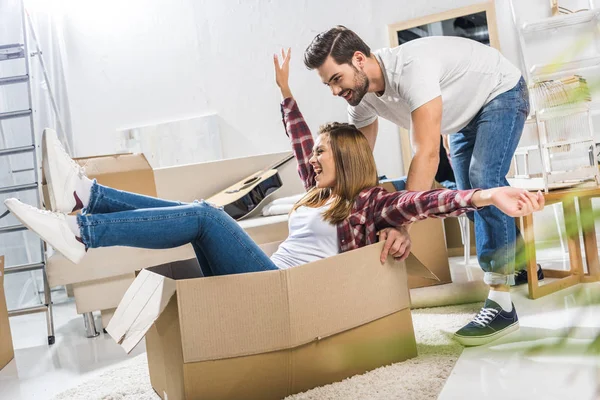 Young couple playing with moving boxes — Stock Photo, Image