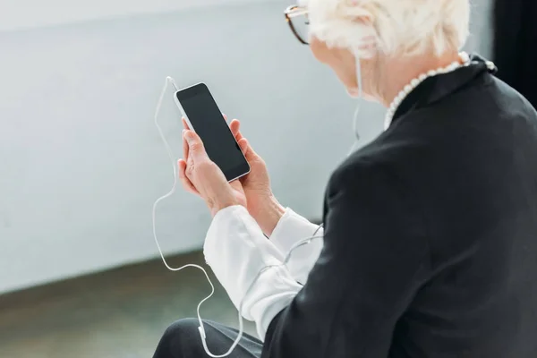 Senior dame écouter de la musique avec smartphone — Photo