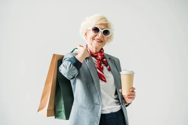 Senior vrouw met boodschappentassen en koffie — Stockfoto