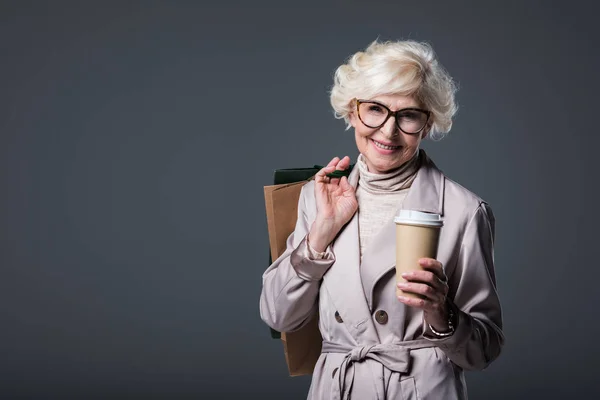 Mujer mayor con bolsas de compras y café — Foto de Stock