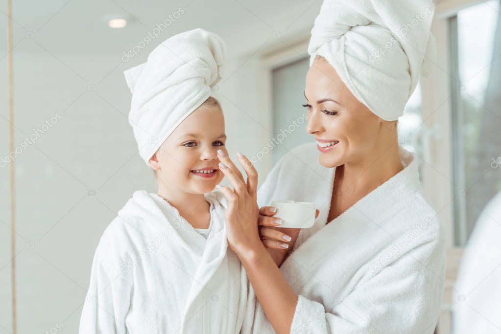 mother and daughter applying face cream