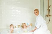 Mutter wäscht Kinder in Badewanne