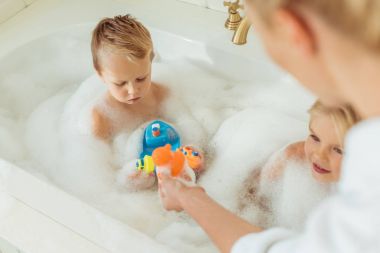 mother washing kids in bathtub clipart