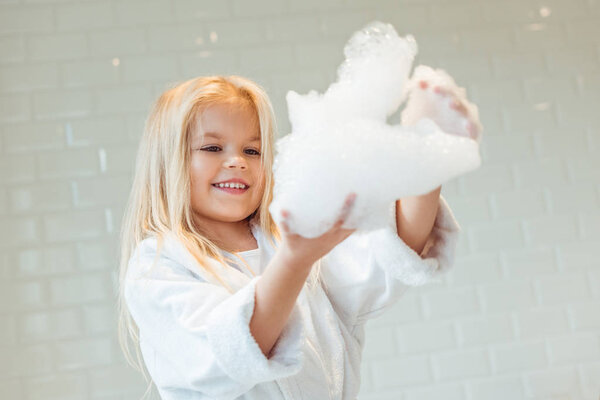 child playing with foam in bathroom